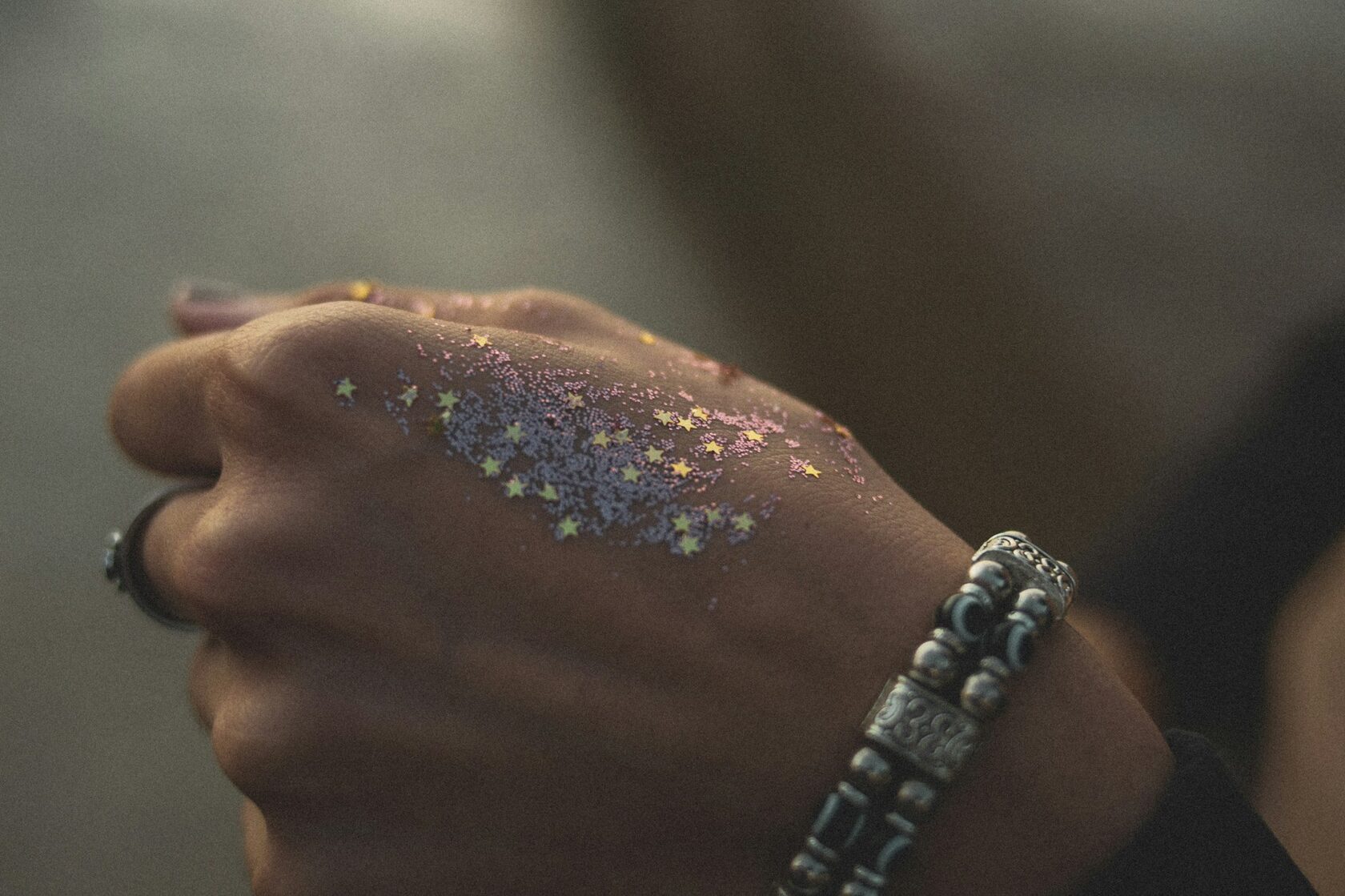 Shimmering glitter tattoo on an adult arm at a festival