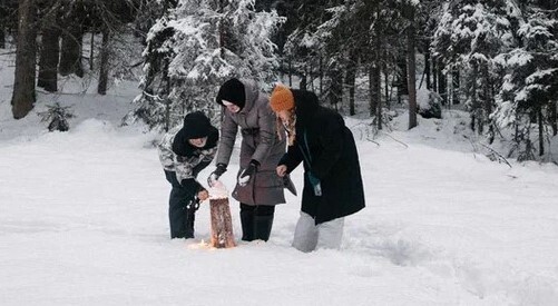Туристы на скале Хауккариутта на острове Хавус, вид на зимние Ладожские шхеры