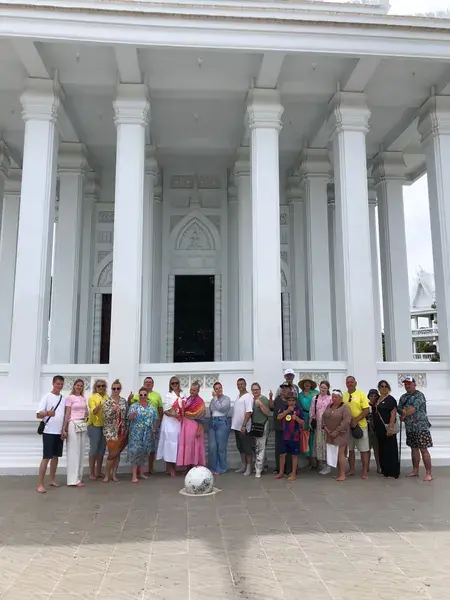 Группа туристов у белого храма с колоннами