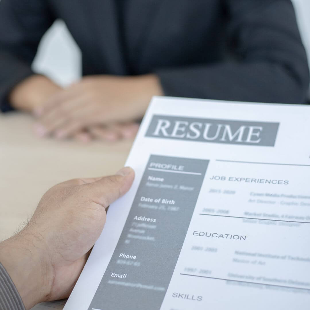 a person holding a resume in front of another person