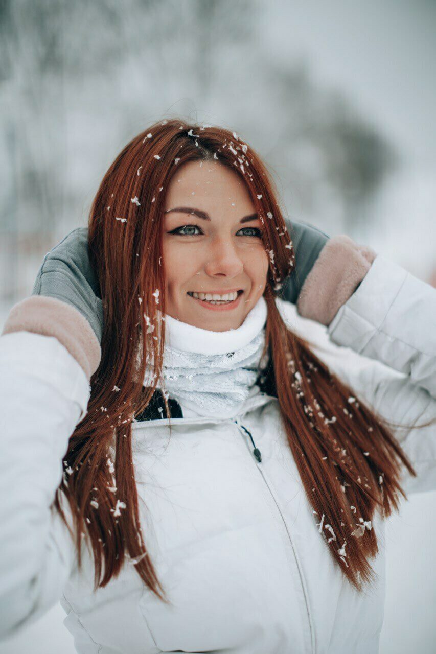 Девушка в снежных горах в белом баффе из плюша