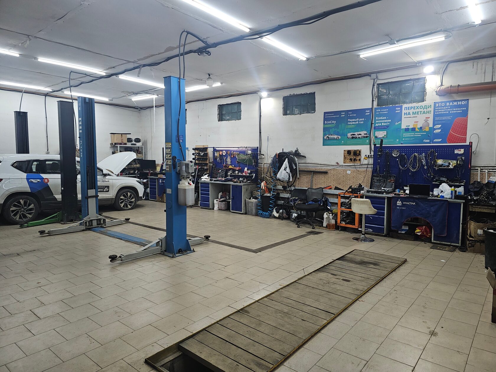 Мастер устанавливает газовое оборудование на двигатель автомобиля