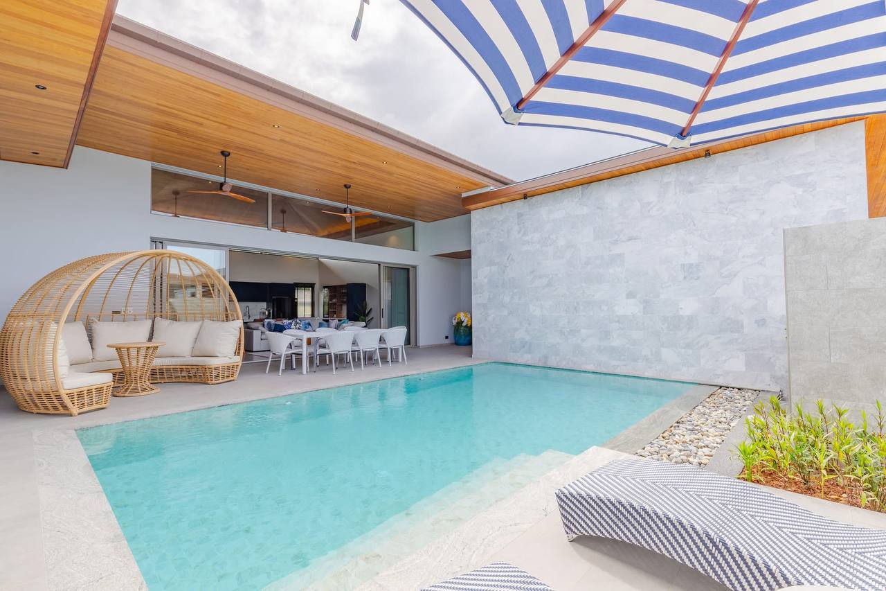 Вилла с бассейном и зоной отдыха у воды.