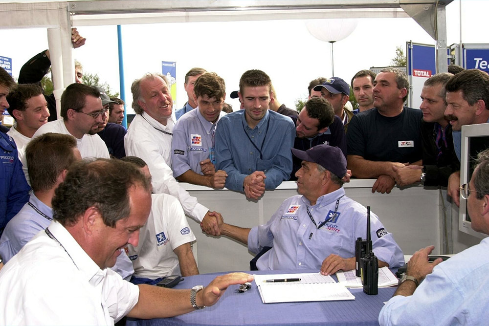 Руководитель команды Subaru Дэвид Ричардс поздравляет босса Peugeot Sport Коррадо Проверу с победой в ралли Сан-Ремо 2001