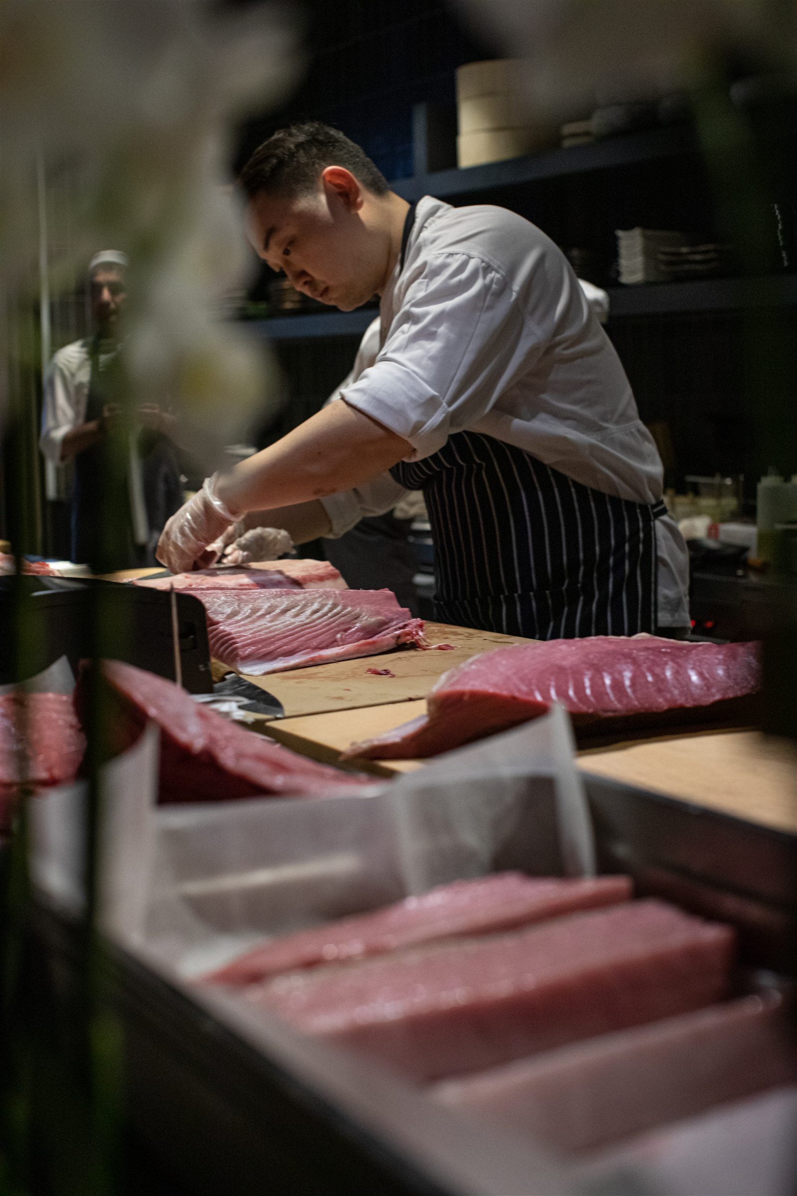 Шеф разделывает тунца на глазах у гостей в Novikov Restaurant & Bar