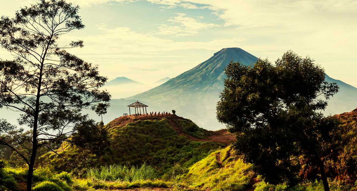 Типичный пейзаж Центральной Явы с вулканическими вершинами, которые идеально наблюдать ранним утром
