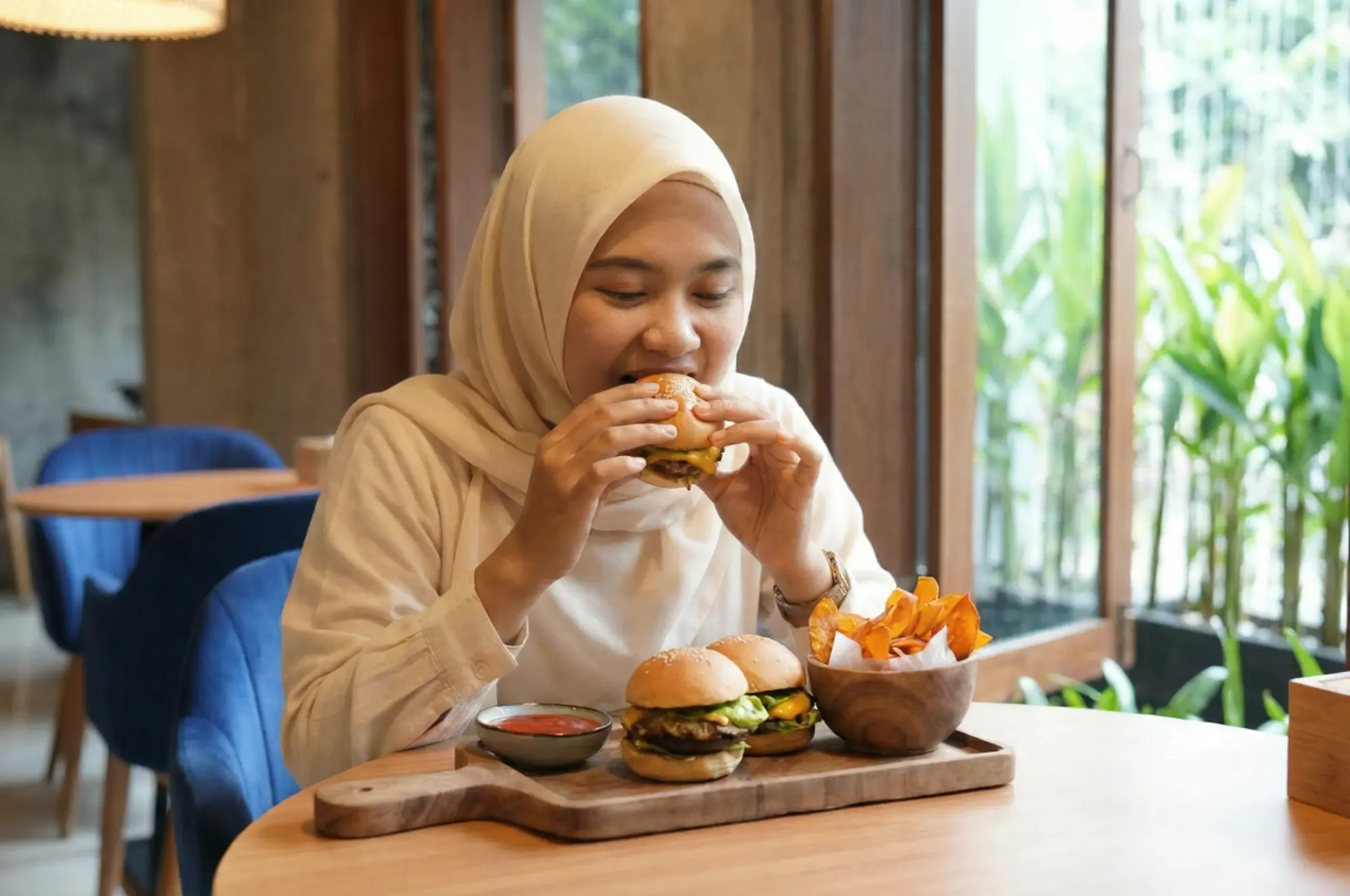 A happy Muslim traveler enjoying a delicious halal burger in Ubud at Eden Hookah Club, perfectly capturing the joy of finding pork-free dining in Bali