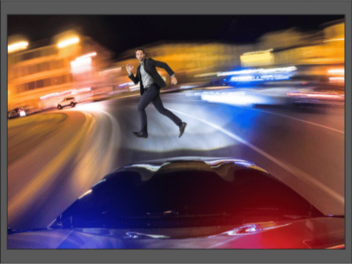 Мужчина убегает по ночной улице, преследуемый полицией и машинами с мигалками.