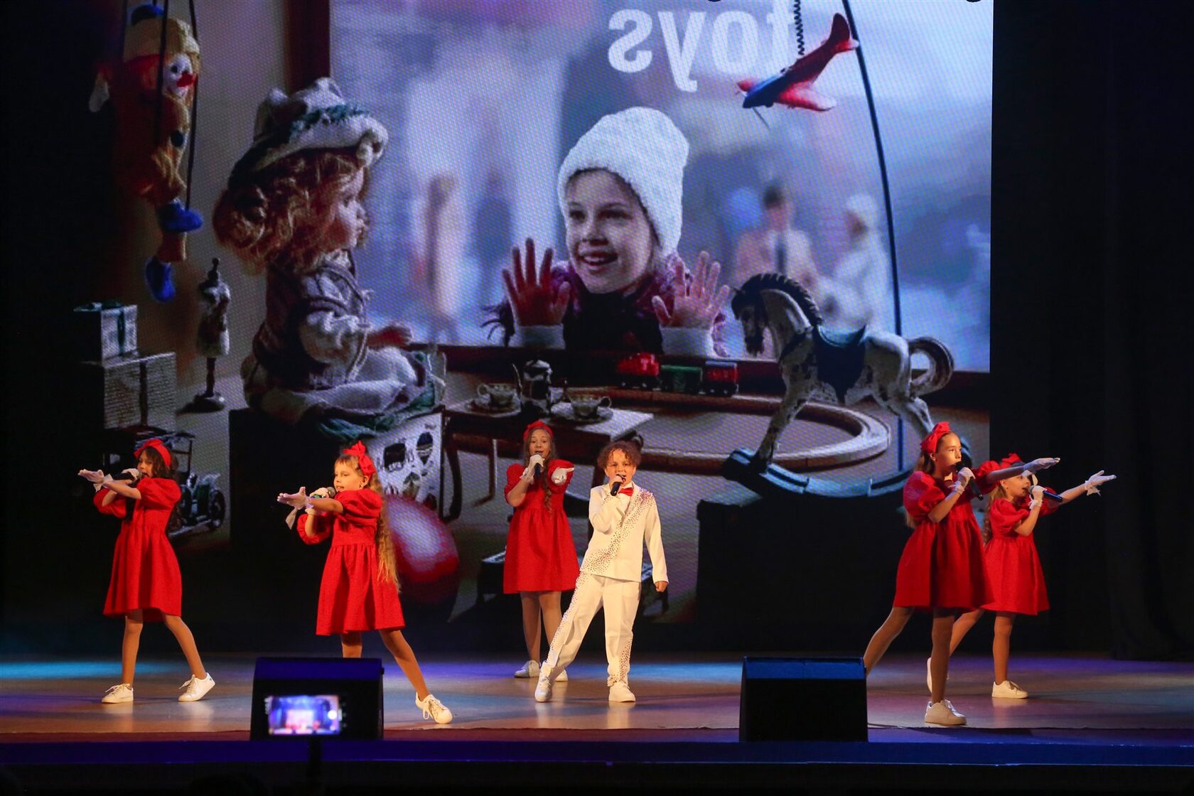 Ансамбль Stage в красных костюмах исполняет концертный номер
