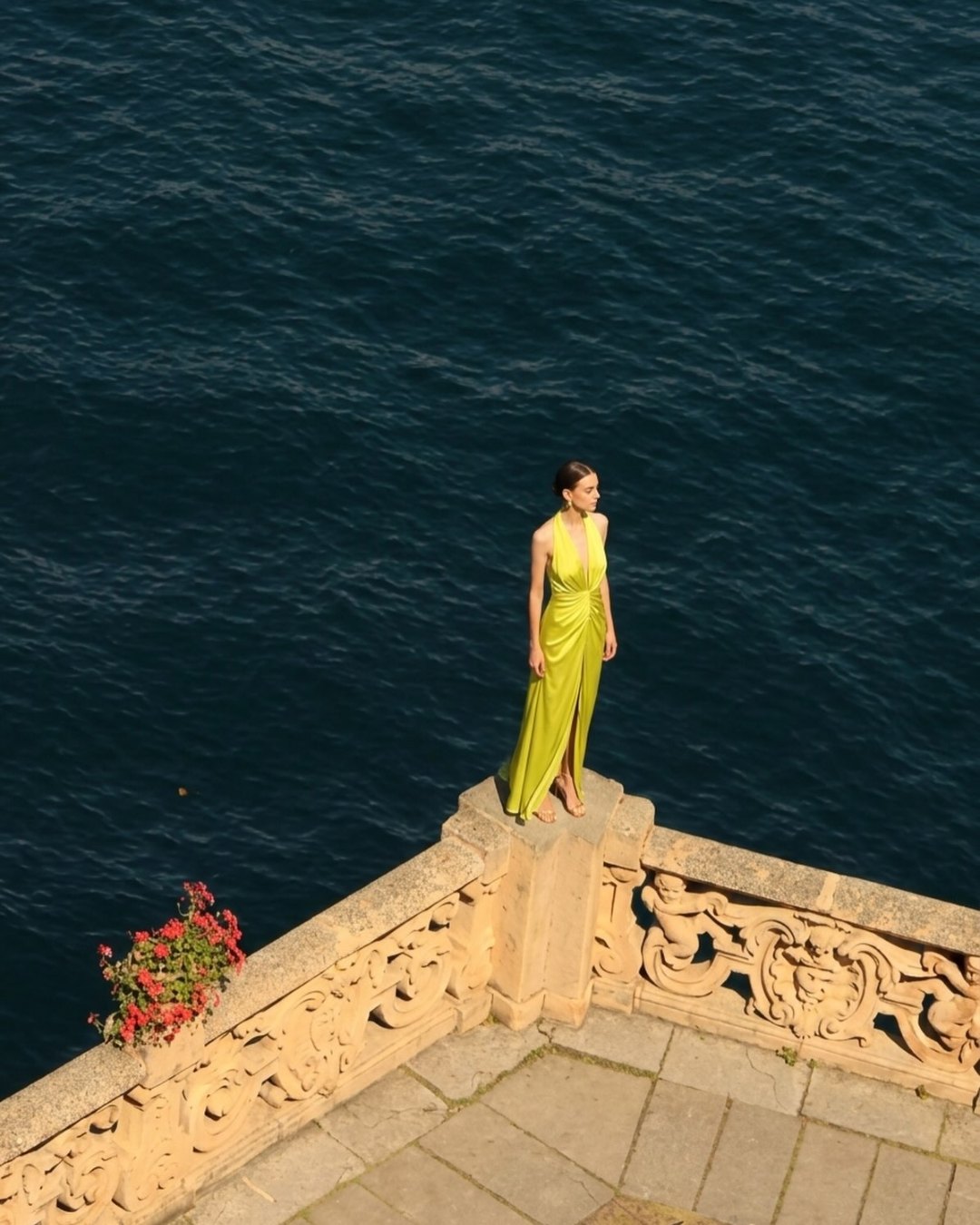 Actualee Primavera-Estate 2026: abito lungo drappeggiato color lime su una terrazza sul mare