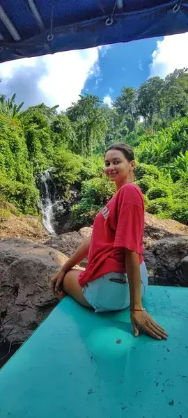 Девушка на лодке у водопада в джунглях