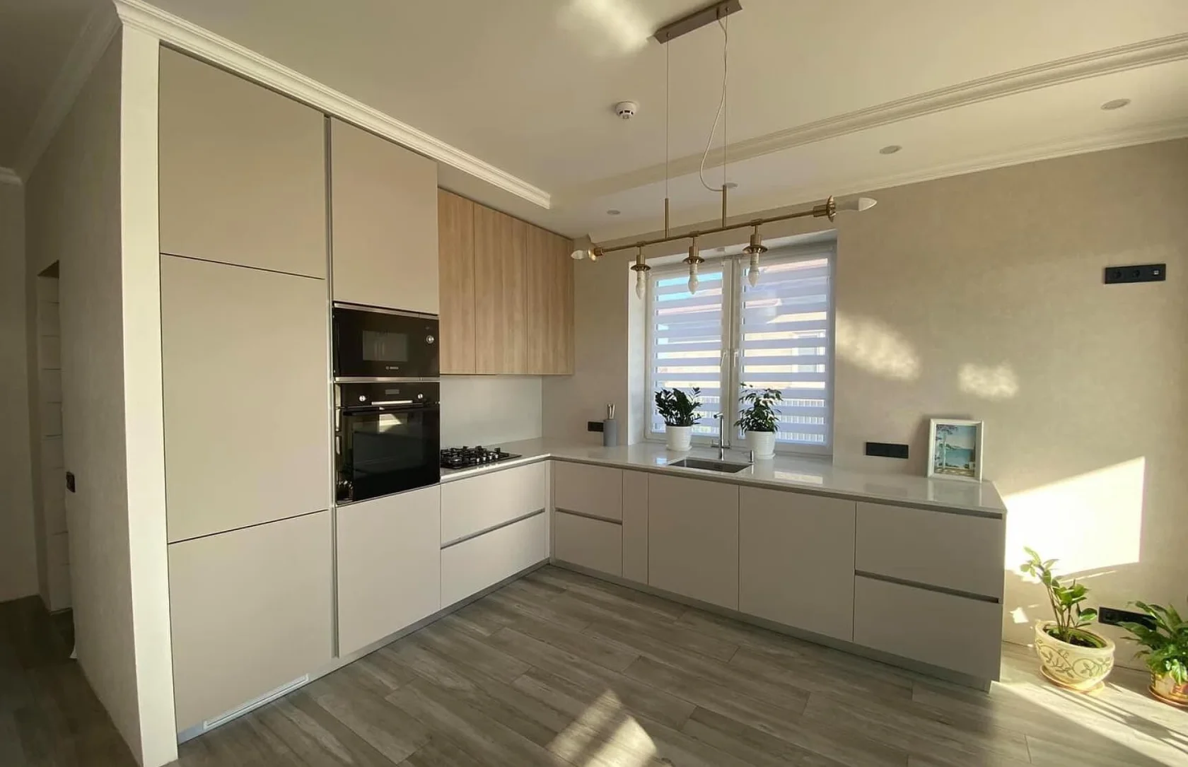 Угловая бежевая кухня со встроенной техникой