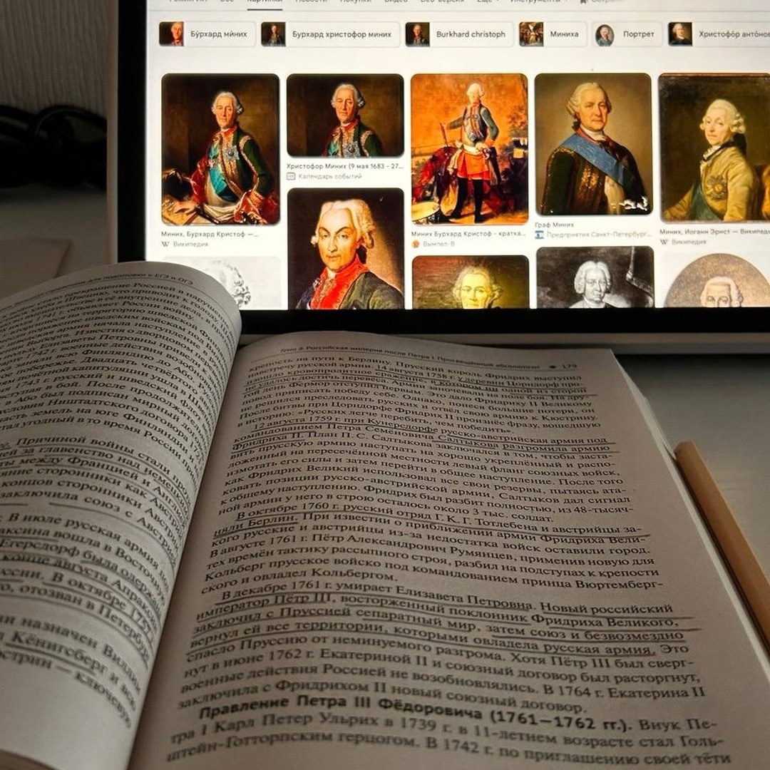 Учебник истории рядом с ноутбуком, на экране портреты по теме занятия