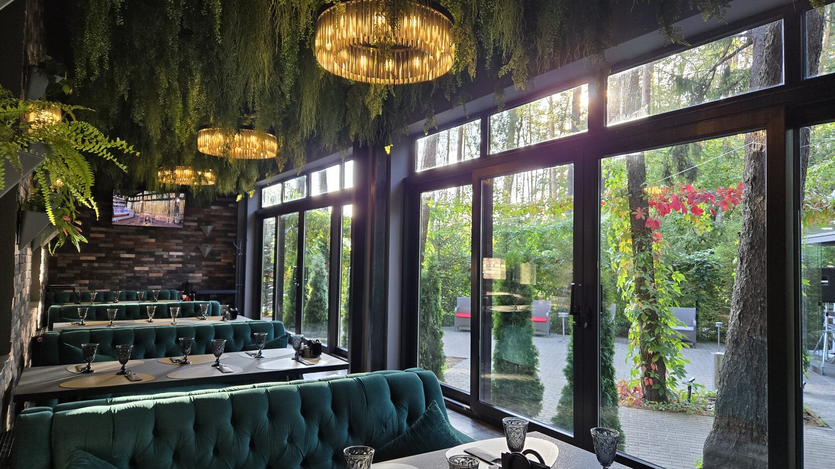 Панорамная веранда Жуковский LOFT с зелёными диванами и окнами в лес