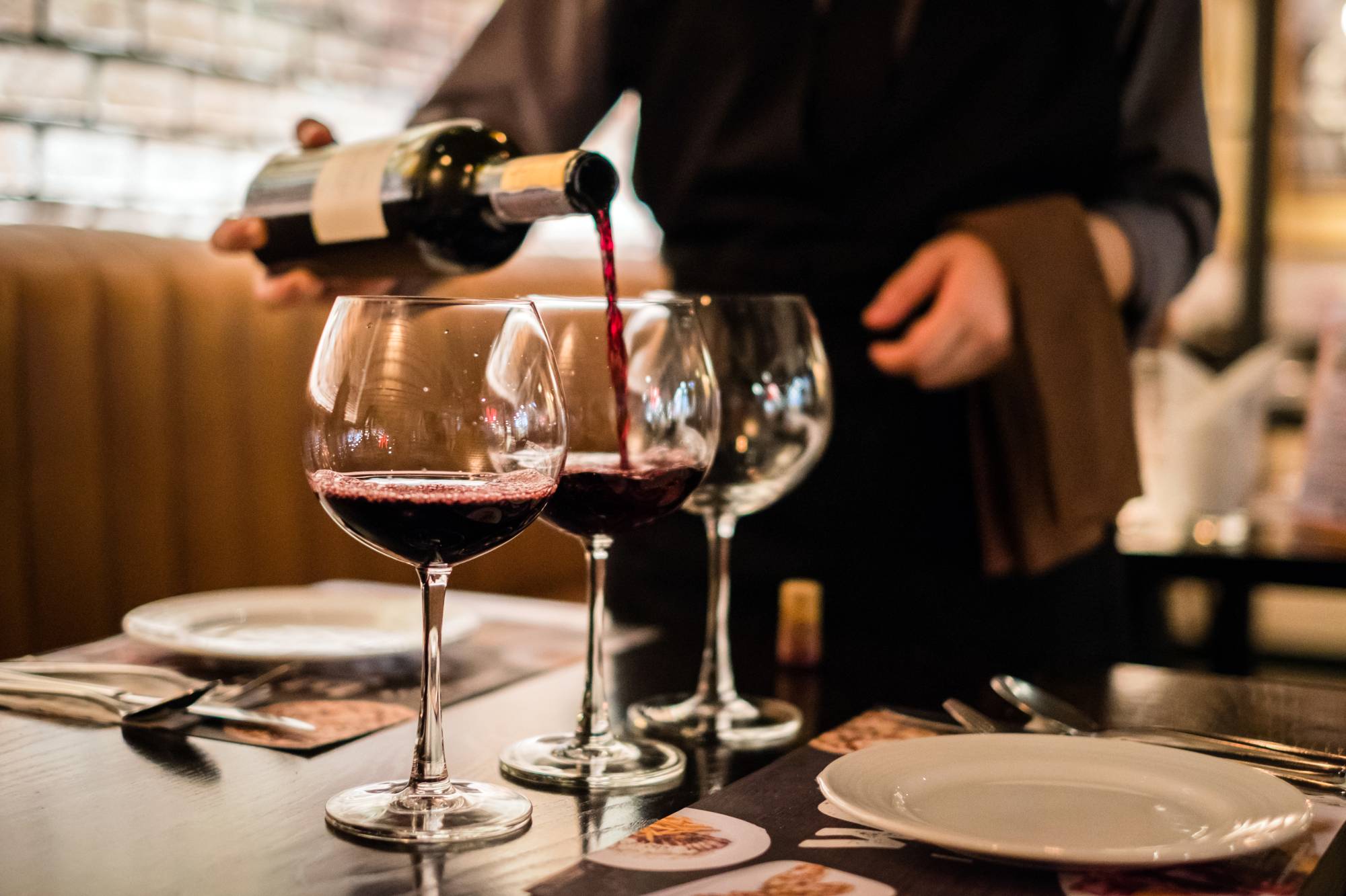 Бокал вина в ресторане. Бокал с вином. Вино наливают в бокал. Красное вино в бокале.