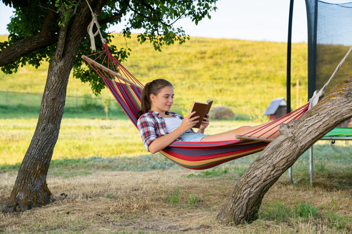Девушка в гамаке читает книгу