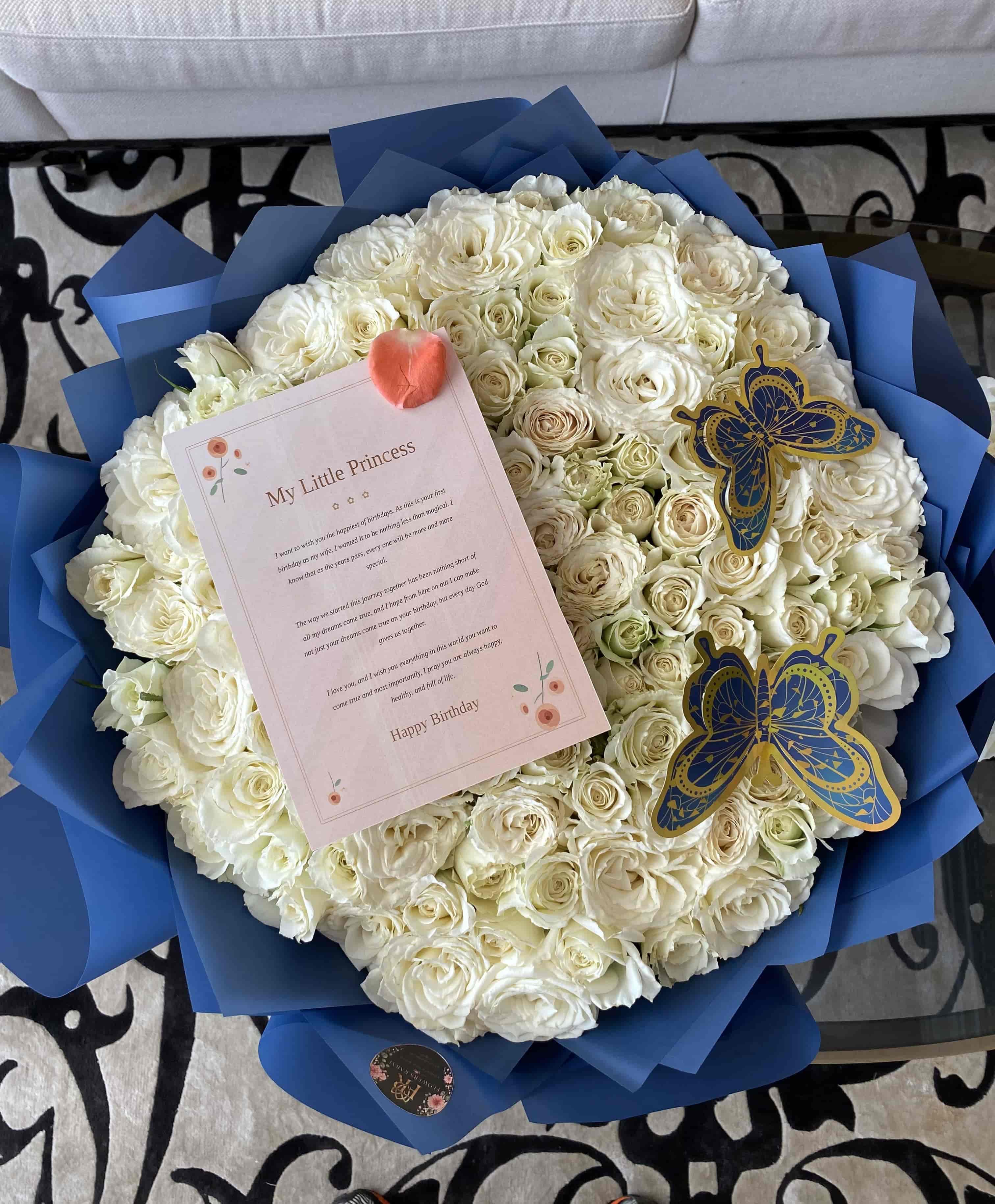 Luxury white rose bouquet with blue wrapping for birthday flower delivery in Morocco