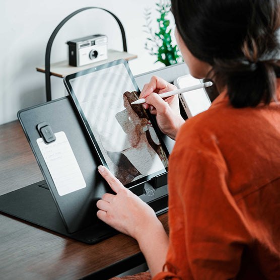 Девушка рисует стилусом на планшете, установленном на коврике MOFT Smart Desk Mat
