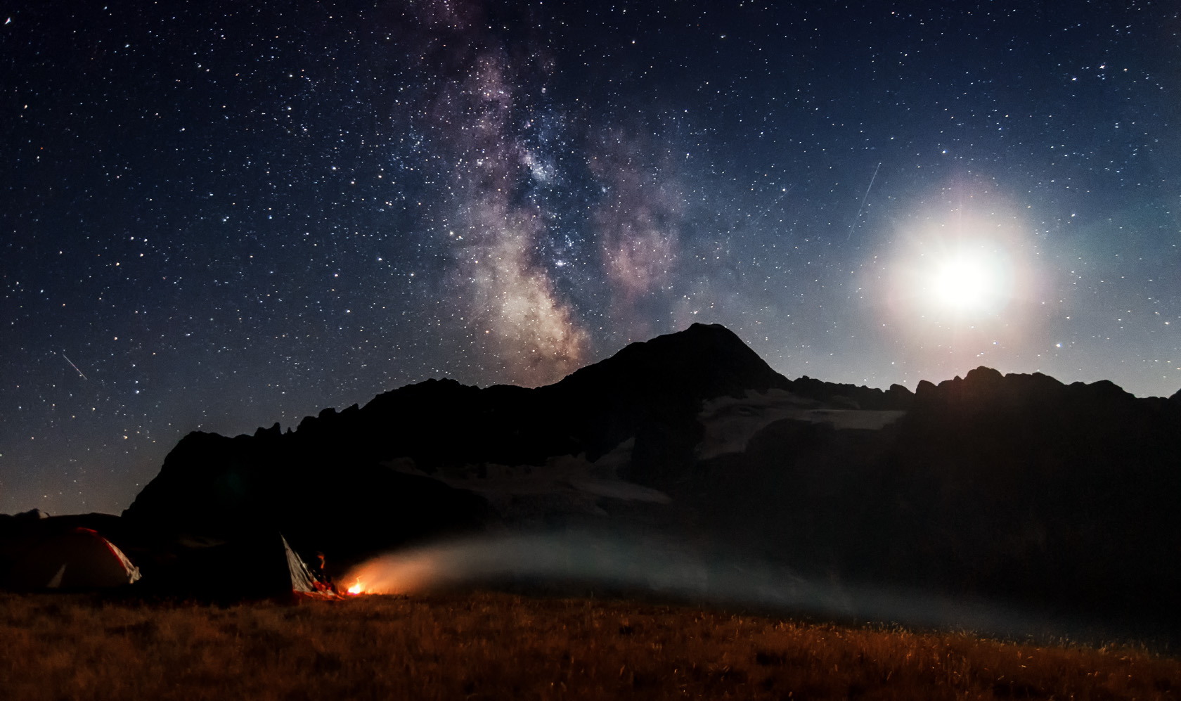 Центр млечного пути и закат луны над вершиной горы София. Карачаево-Черкесская республика, район поселка Архыз. Костер в горном лагере Фотограф Севальнев Ян..