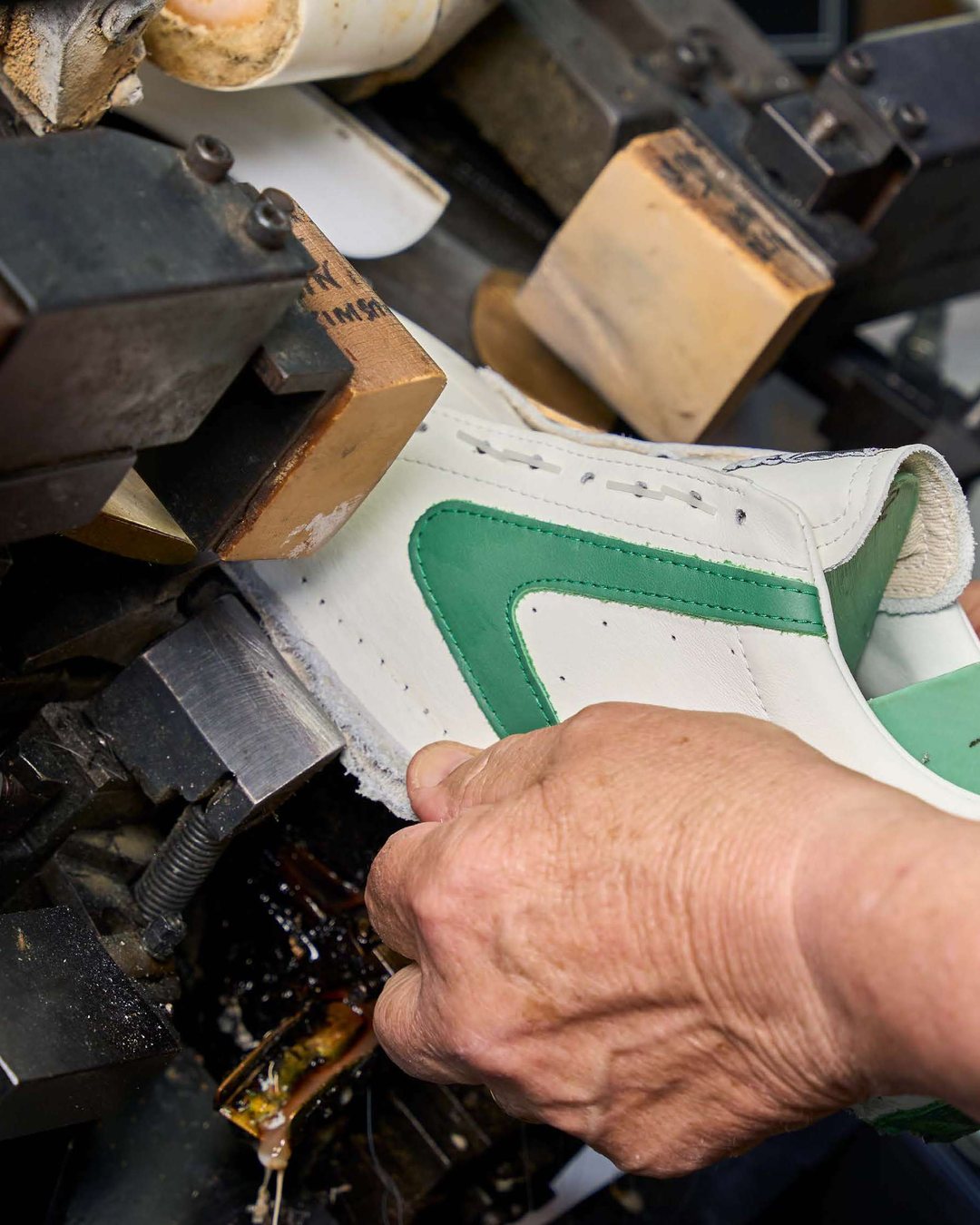 Valsport: artigiano al lavoro su una sneaker in pelle bianca e verde