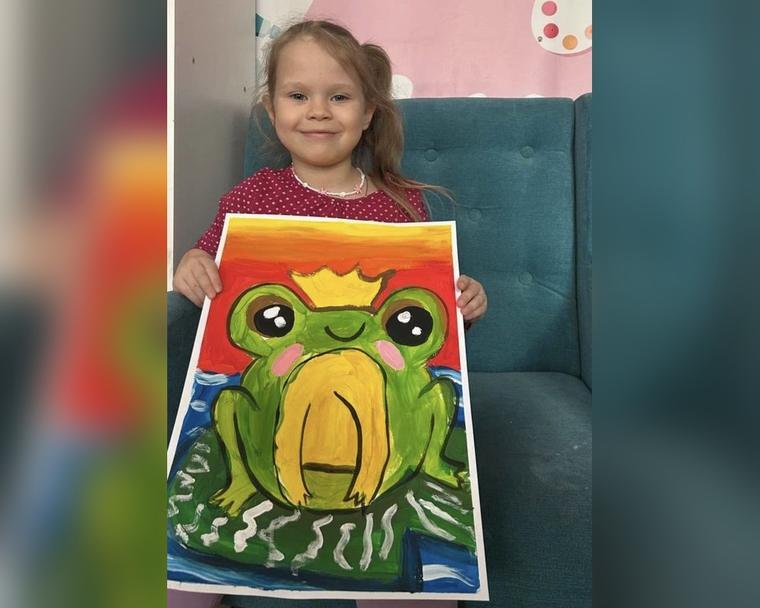 Девочка 3–4 лет с гуашевой работой «Царевна-лягушка» на занятии ИЗО