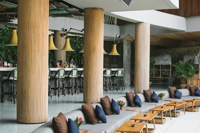 Sleek sunken lounge seating and iconic architectural pillars inside Potato Head Beach Club, a staple of Seminyak's day-to-night bar scene.