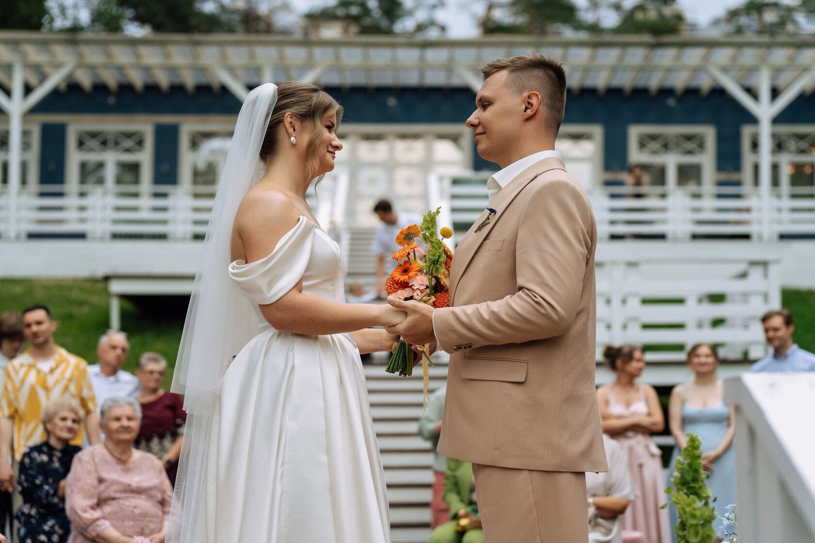 Выездная свадебная церемония на природе: жених и невеста во время обмена клятвами, стильная свадьба с живыми цветами