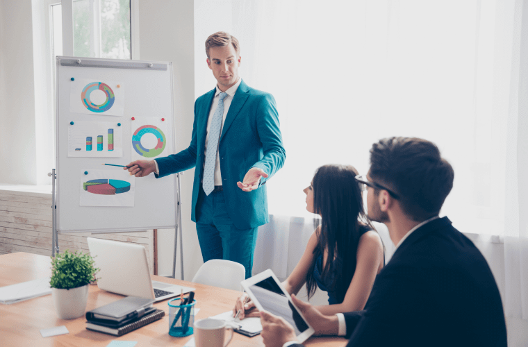 бизнесмен показывает диаграммы на флипчарте