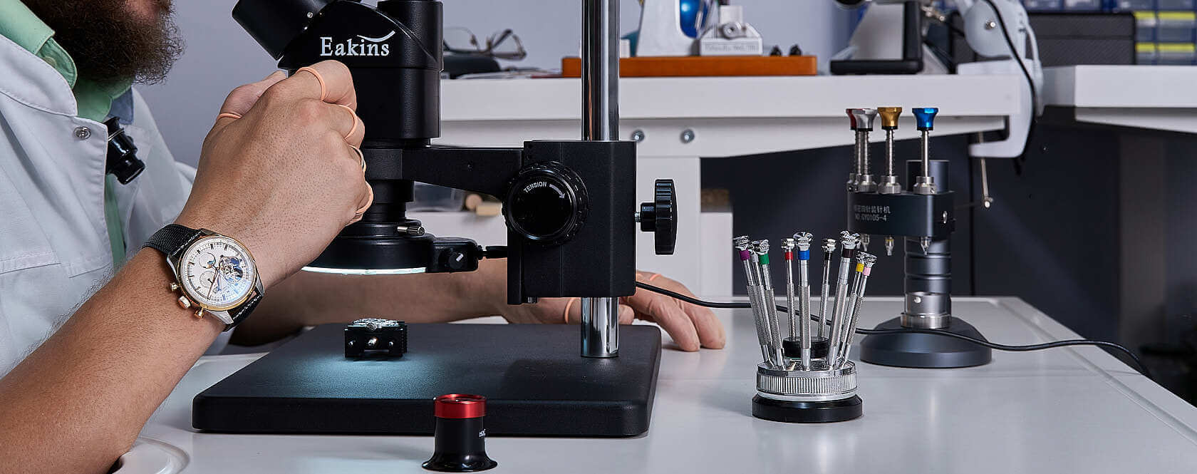 Мужчина чинит наручные часы в мастерской