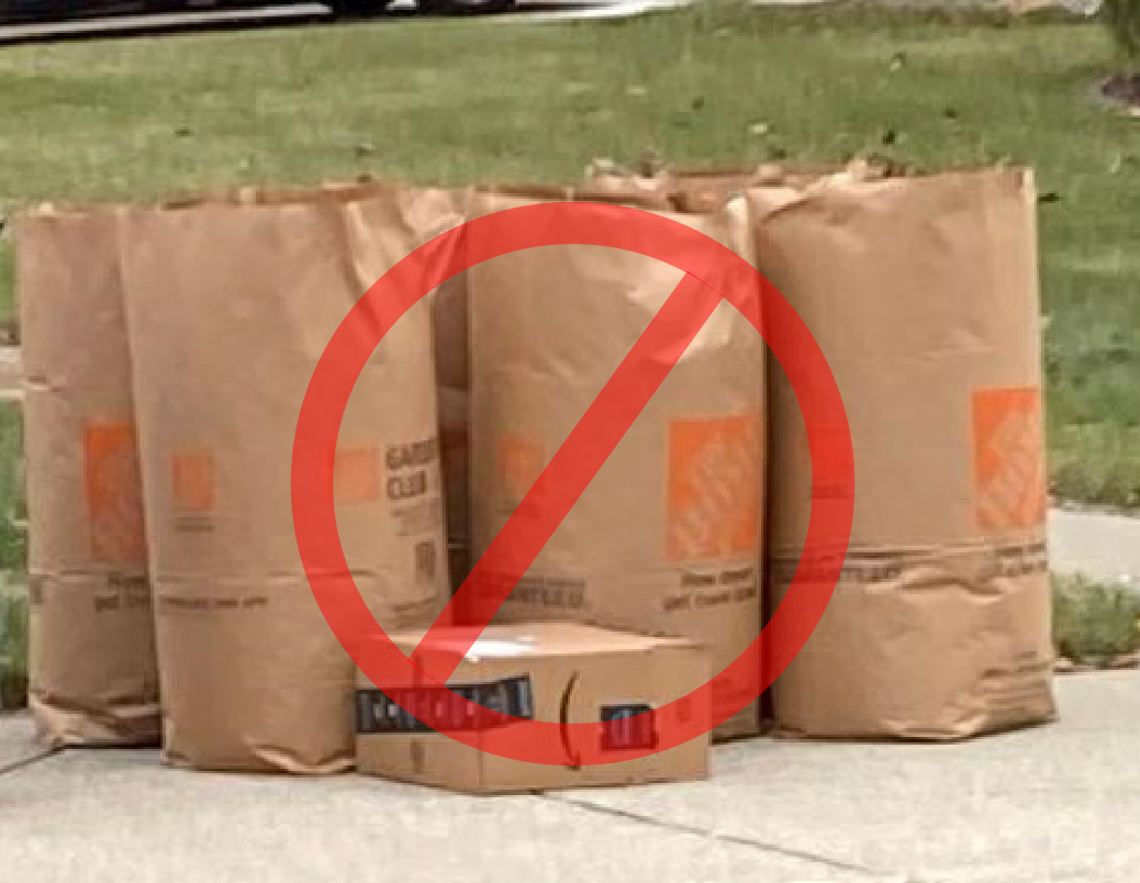 Three large, full garden and lawn waste bags sitting on a sidewalk. A circle with a slash through it is superimposed over the image indicating do not use.