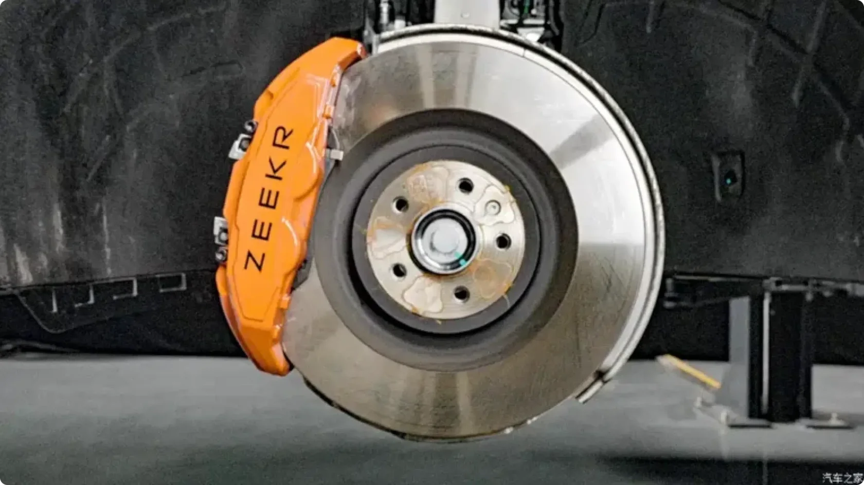 Передний четырехпоршневой тормозной суппорт Brembo оранжевого цвета и вентилируемый тормозной диск на ступице Zeekr 8X