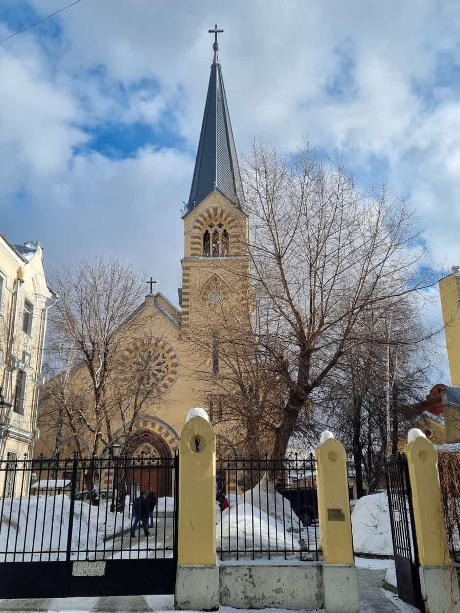 Неоготическая церковь со стрельчатой башней за оградой