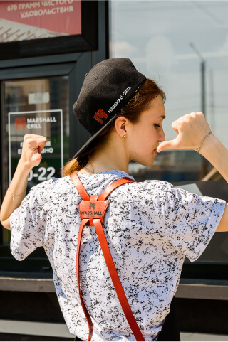 девушка шаурмейкер показывает на своб крутую униформу