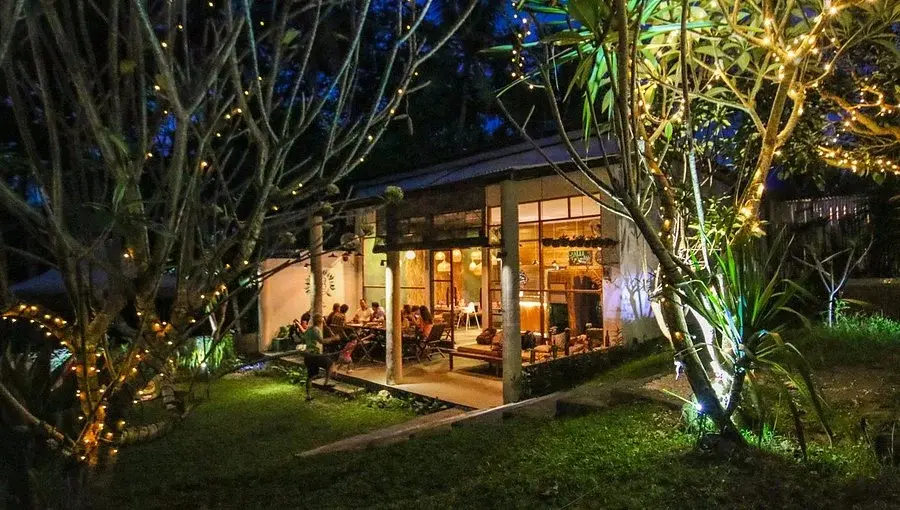 A look inside a warmly lit cafe featuring a wooden counter, large windows, and festive decorations, offering a relaxing spot to enjoy sweet treats and authentic Russian food in Bali.