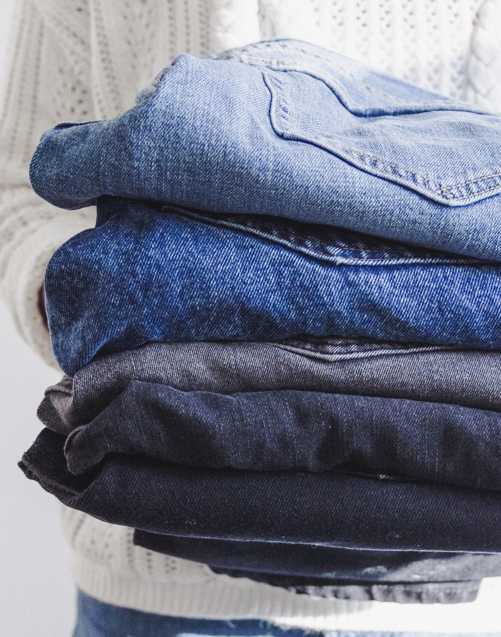 Organiser is holding folded jeans