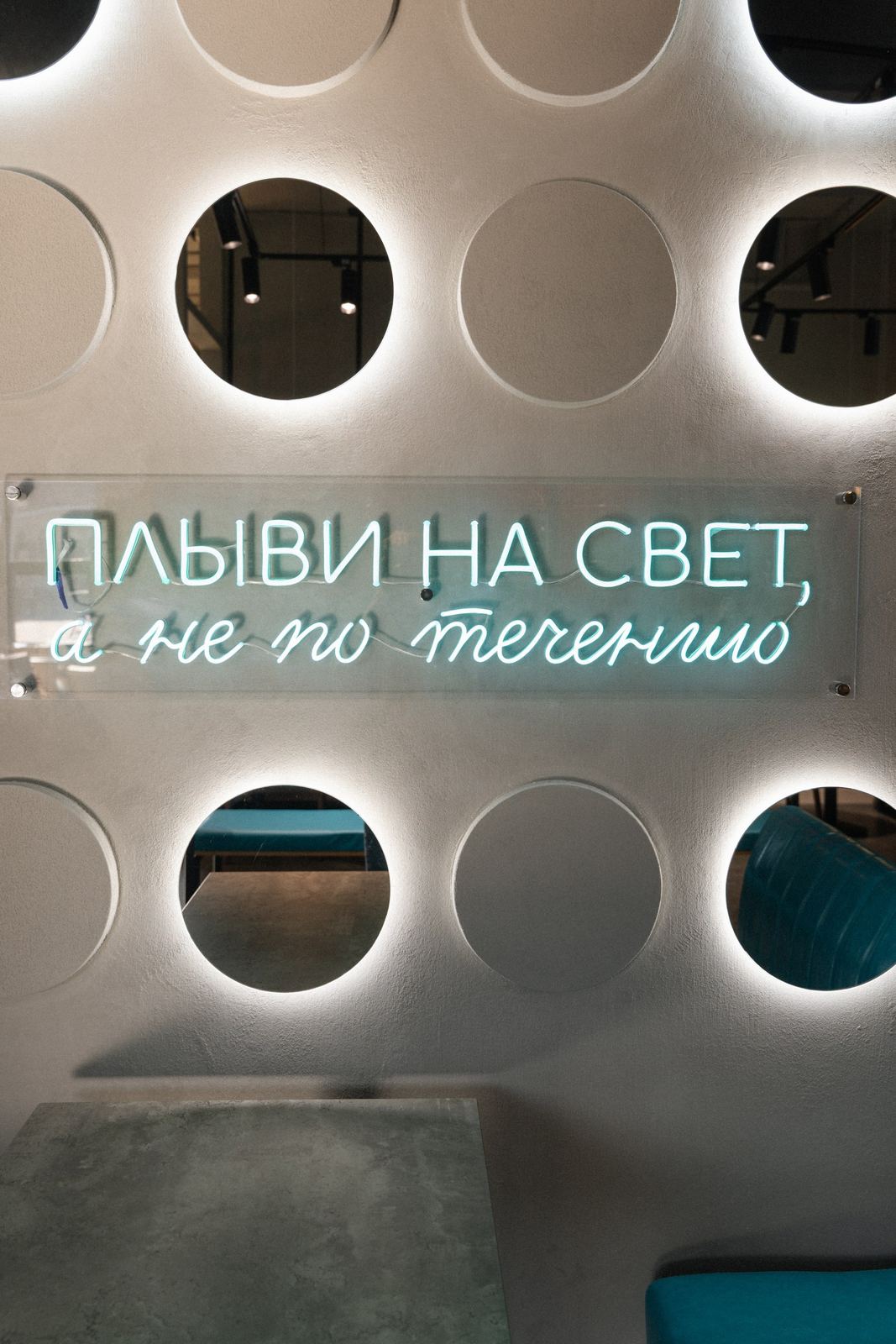 Неоновая надпись среди круглых ниш
