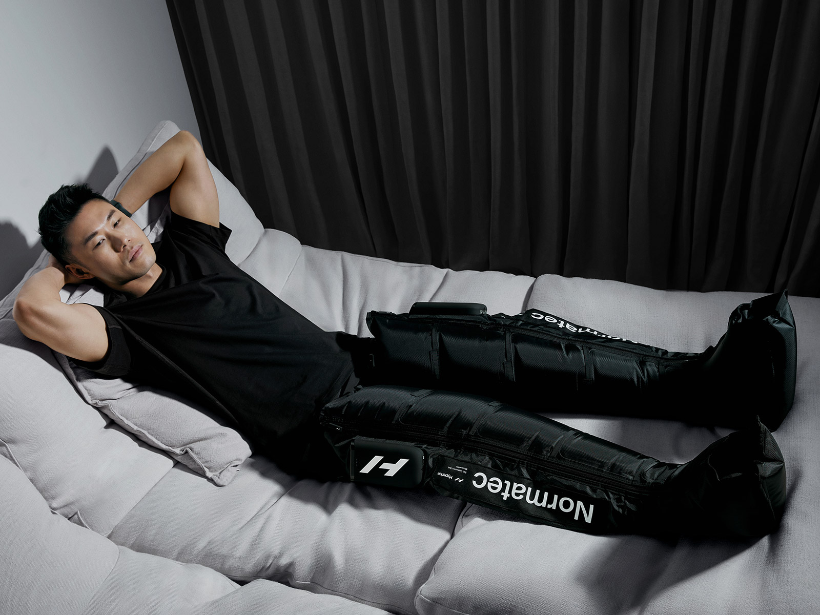 Мужчина отдыхает, используя систему пневмокомпрессии Normatec Elite