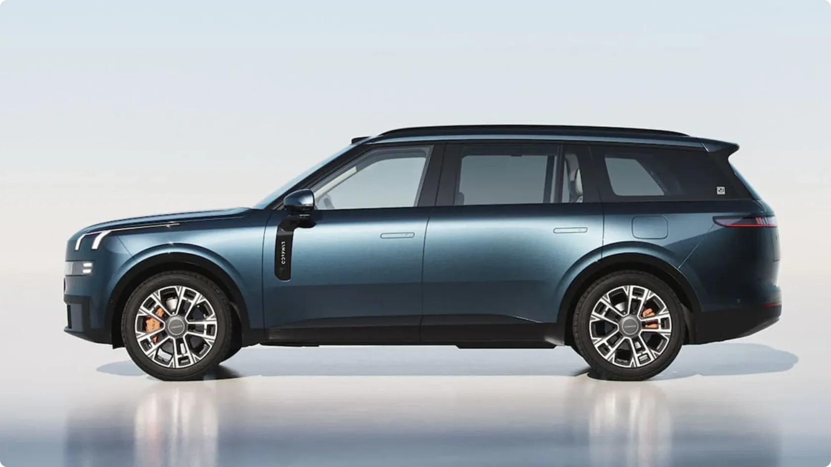 Премиальный гибридный кроссовер Lynk & Co 900 в глубоком синем цвете, вид сбоку: строгий профиль, утопленные дверные ручки, затемненная крыша и крупные многоспицевые диски с оранжевыми тормозными суппортами