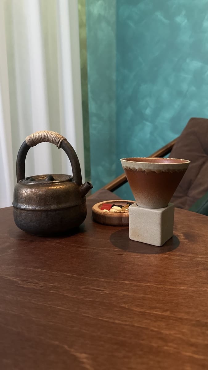 Дизайнерские чайник и чашка на столике в студии ПАУЗА. Угощения (орешки и рахат лукум) и чайная церемония с 9 сортами чая.