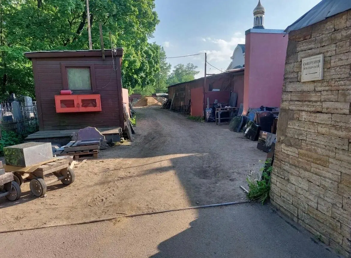 Проход к гранитной мастерской после обхода здания справа на территории Красненького кладбища
