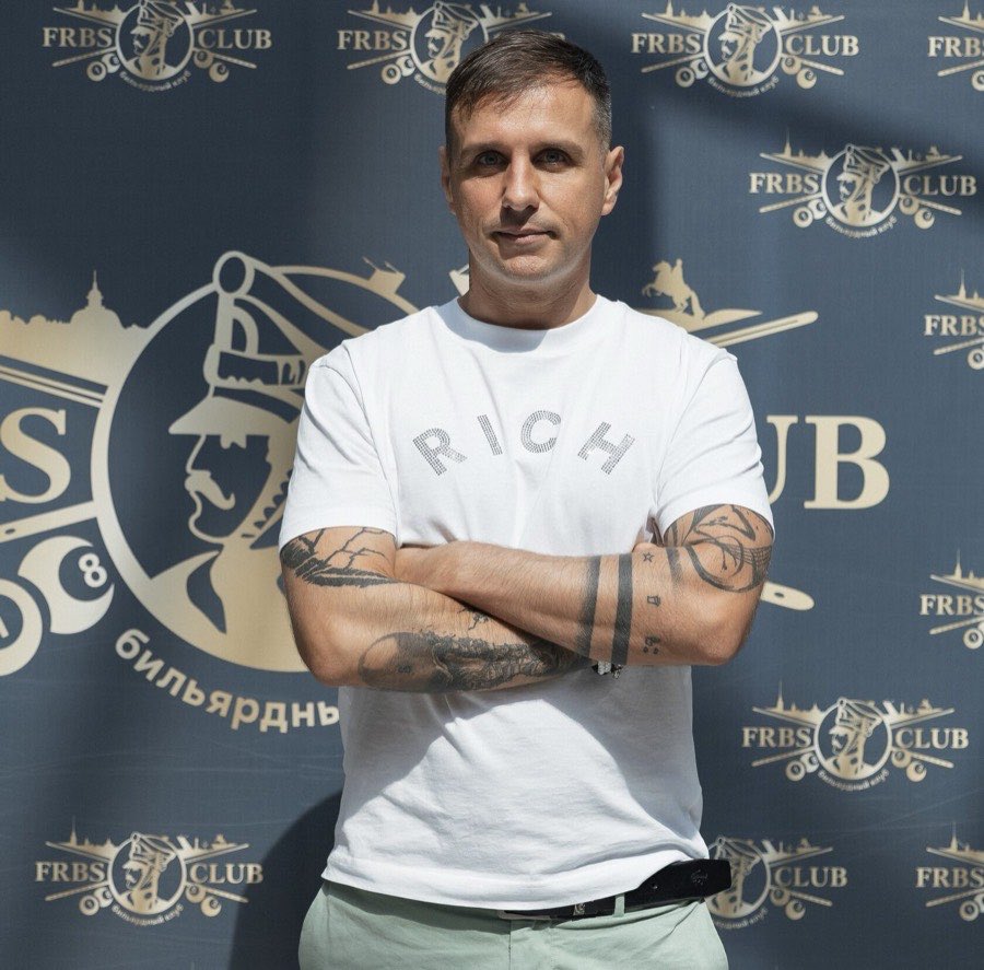 Евгений Прусак на фоне фотостены FRBS-club