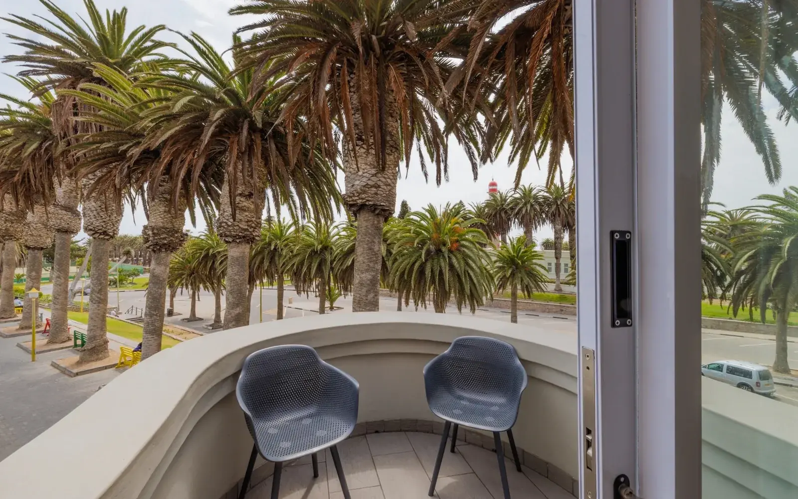 Балкон с креслами и видом на пальмовую аллею, Swakopmund Luxury Suites
