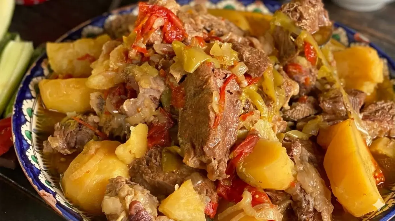 Мясо с картошкой в афганском казане — готовое жаркое с крупными кусками мяса и картофеля в тарелке