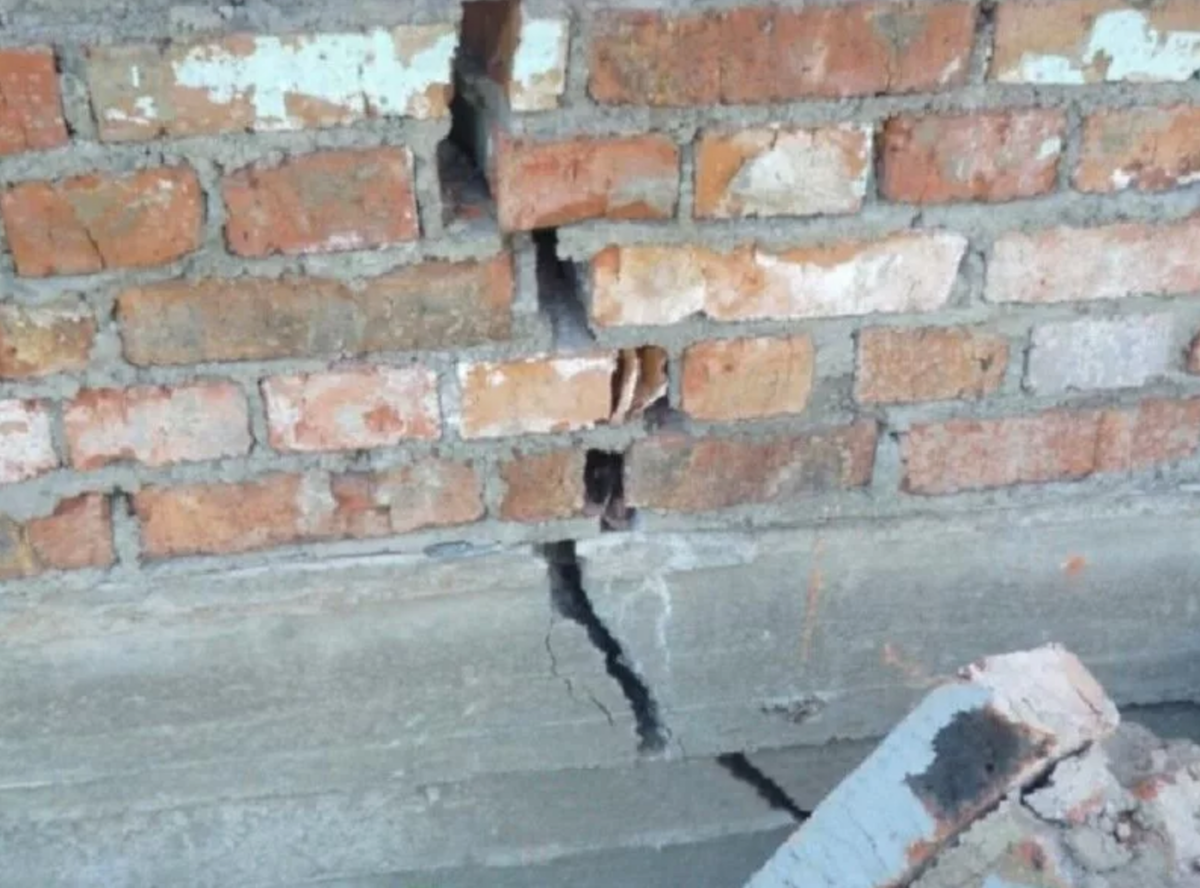 Трещины в стенах дома. Трещины в фундаменте. Трещина в здании. Трещины стен и фундаменты. Трещины в цоколе фундамента.