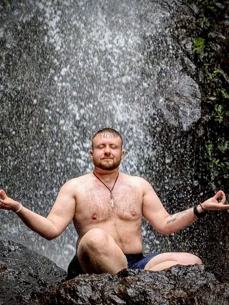 Мужчина сидит под струями воды