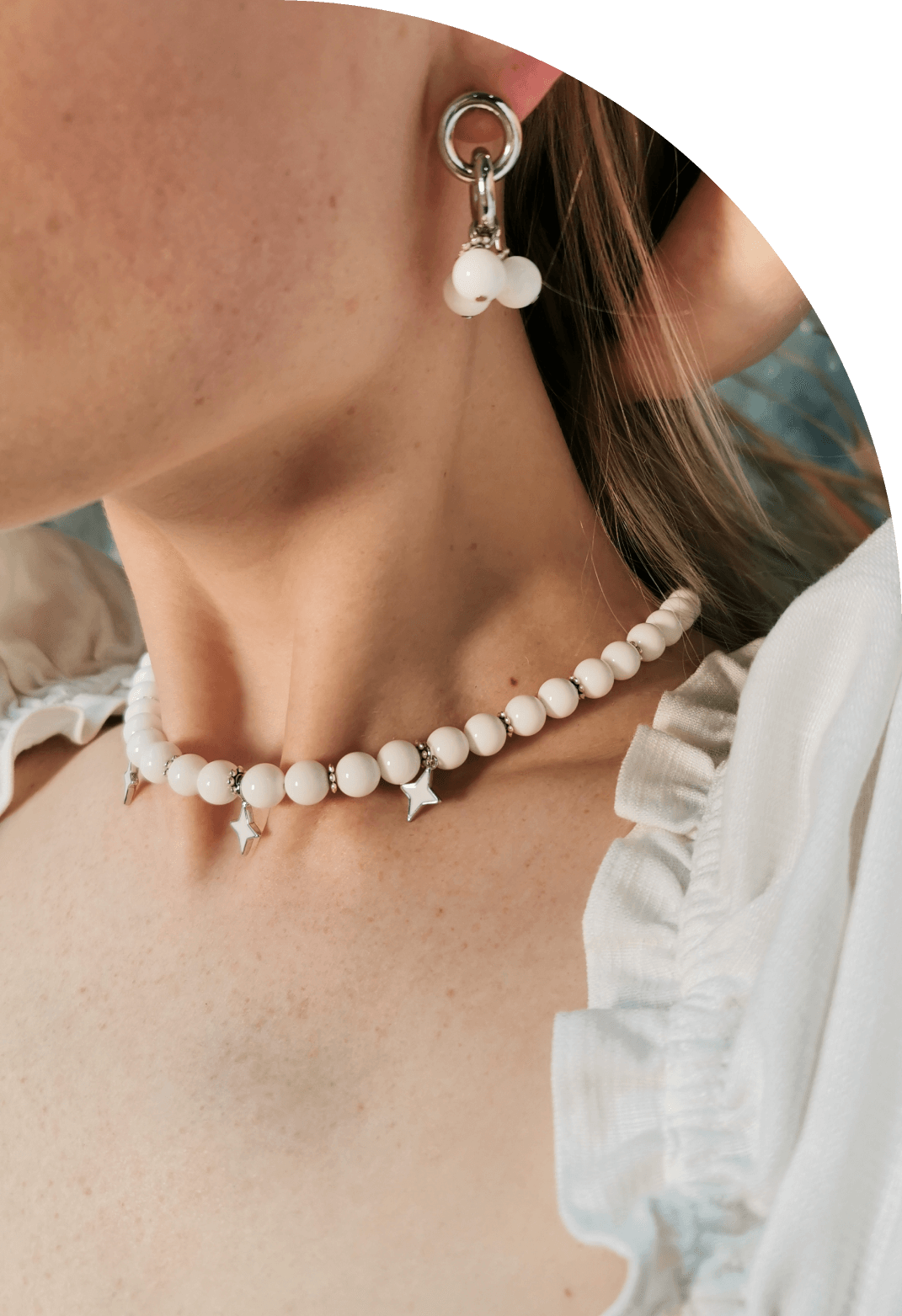 девушка в сережках и колье из белого агата со звездами