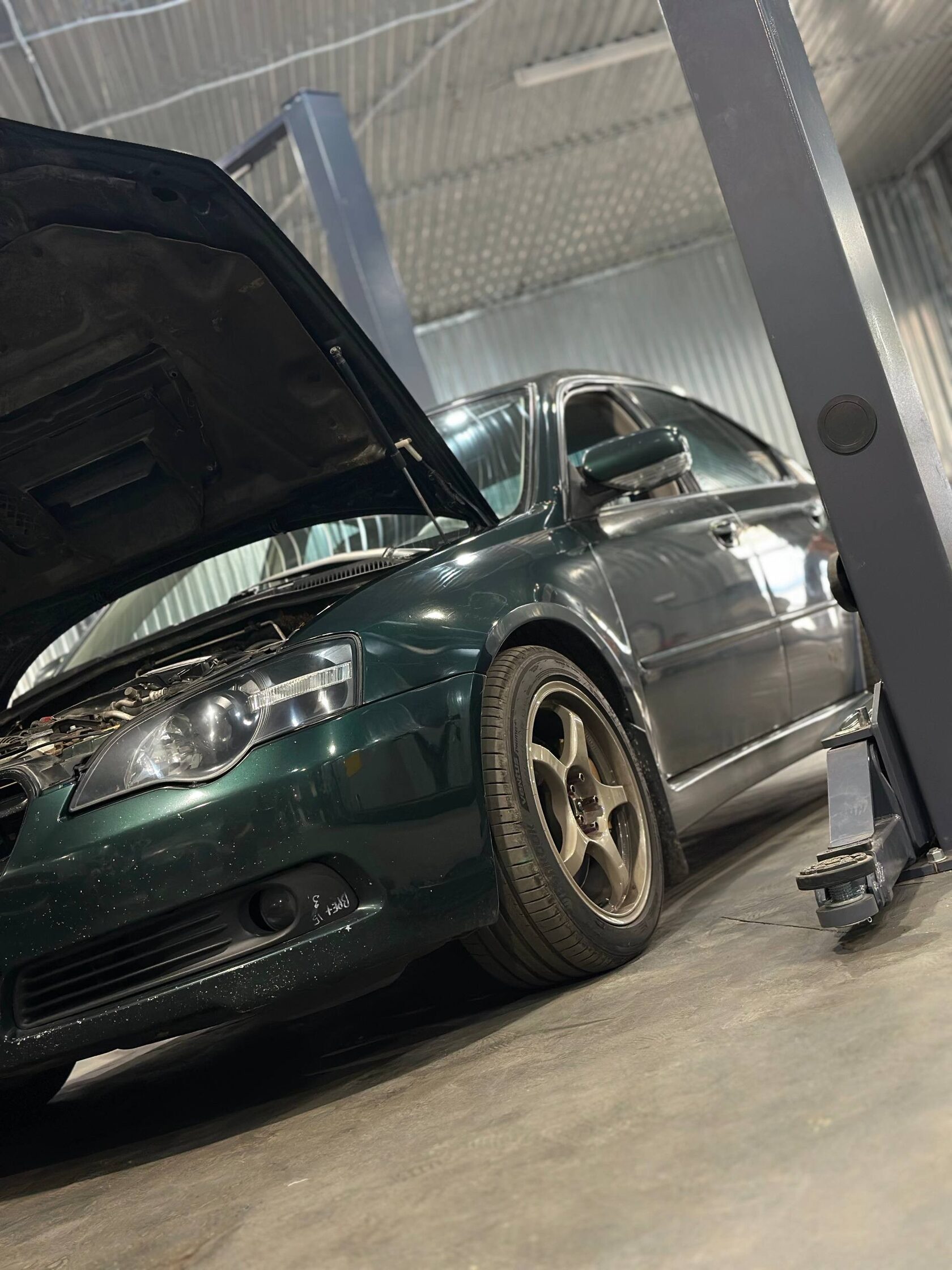 Subaru на подъёмнике с открытым капотом
