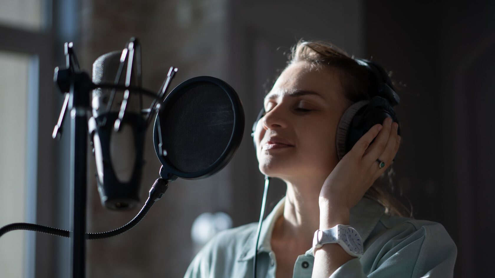 Девушка поет в микрофон на занятиях вокалом