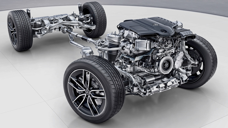 Мастер автосервиса проводит осмотр ходовой части Mercedes-Benz на подъемнике, используя фонарик для детальной диагностики.