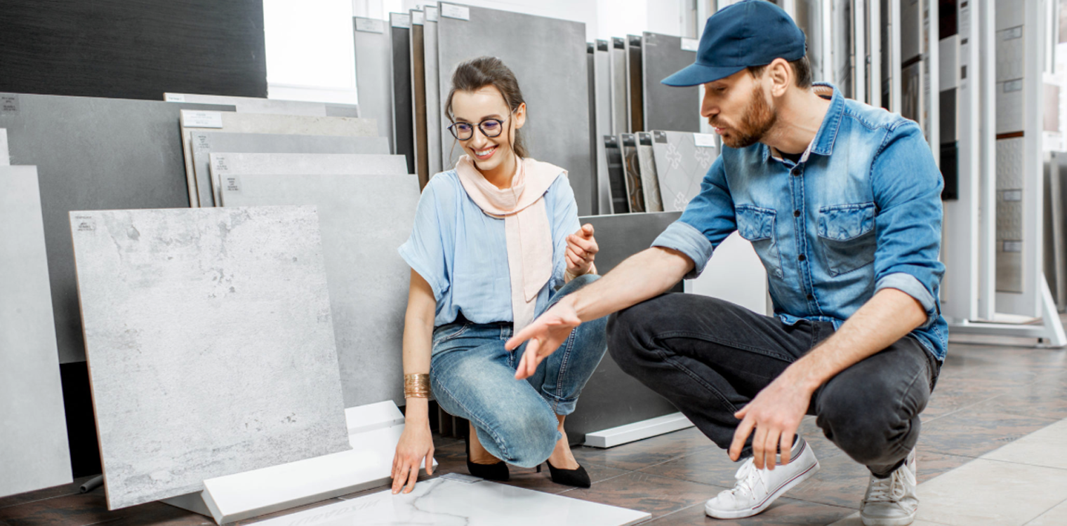 Покупателей плитки. Продавец кафеля. Young woman with Salesman choosing material in Salon. Photo in Tile person.